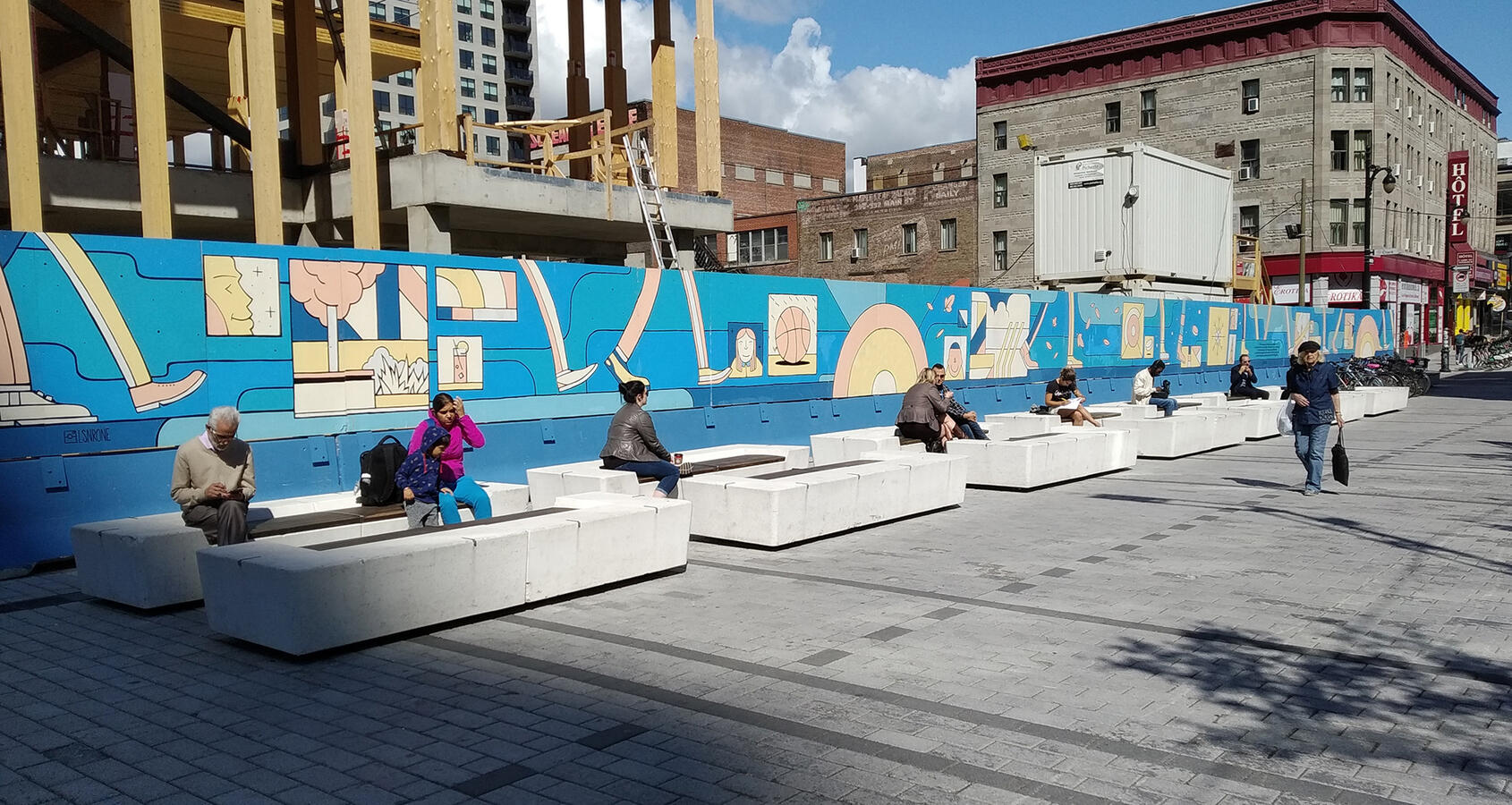 Une longue palissade peinte par l'artiste Lucas Saenger. On y voit des éléments graphiques représentant les 4 saisons.