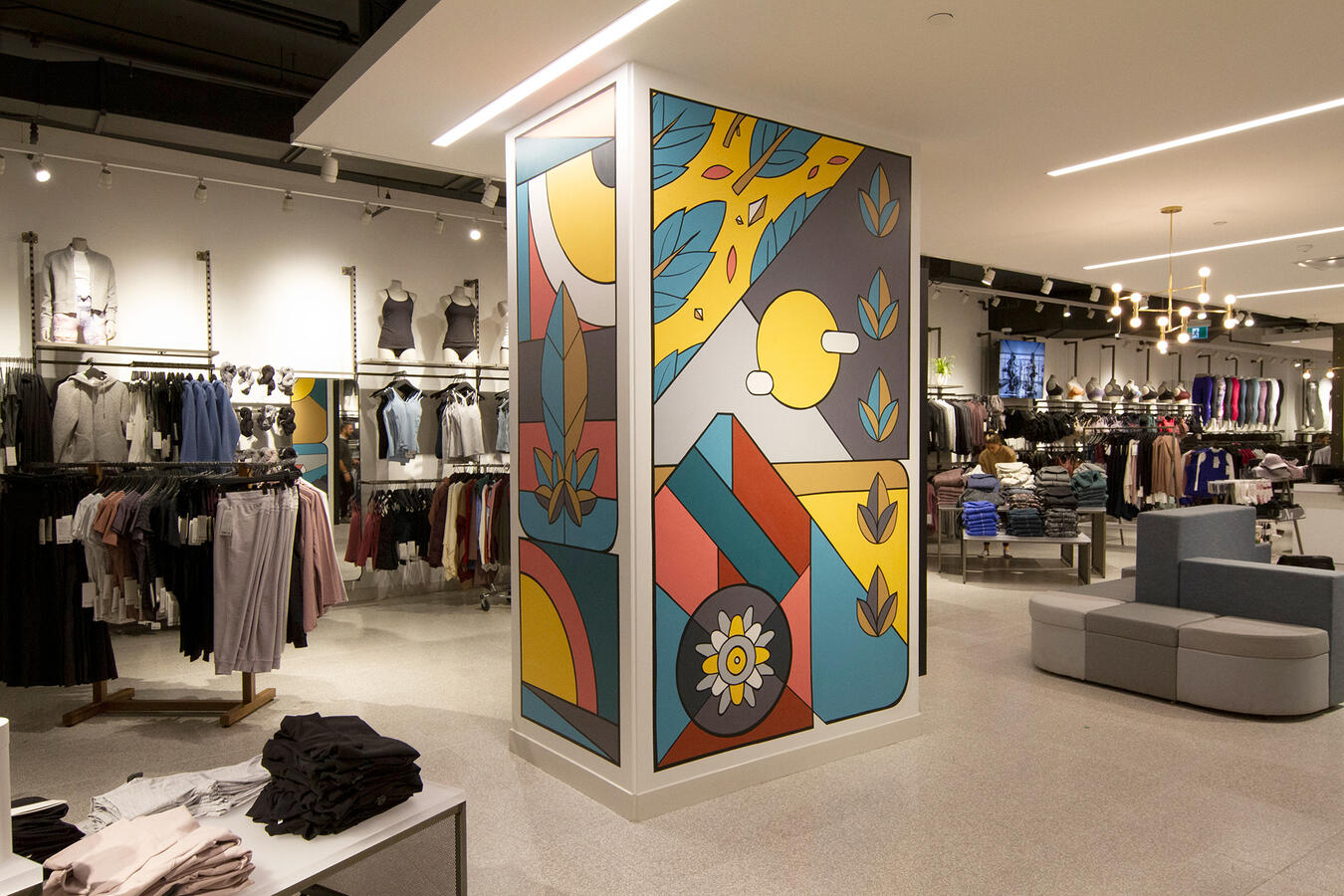 Une colonne peinte par Lucas Saenger, dans un local commercial à Pointe-Claire. On y voit des formes graphiques rappelant des éléments naturels, qui forment une composition.